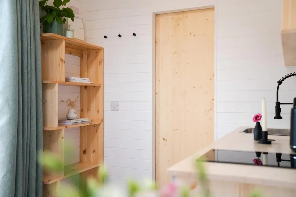 a kitchen with white walls and wooden shelves at Willow's Nordic Shepherds Hut in Ballater