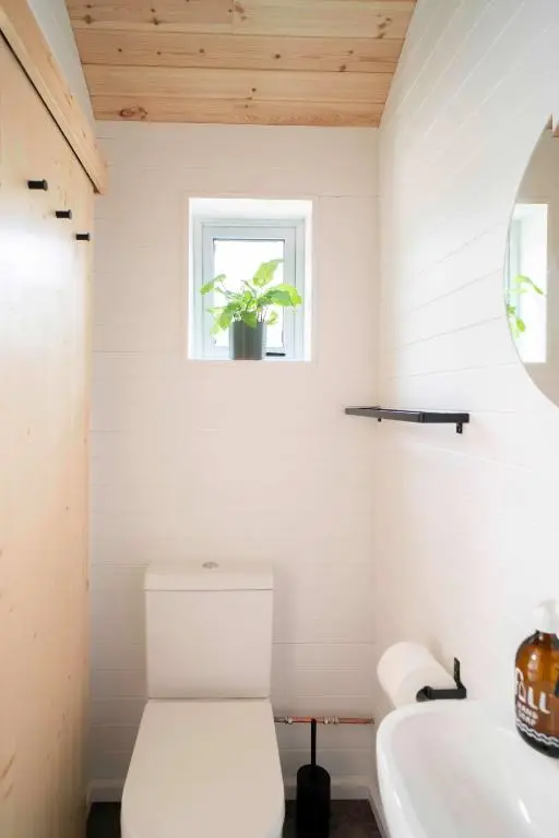 a bathroom with a toilet and a sink and a window at Willow's Nordic Shepherds Hut in Ballater