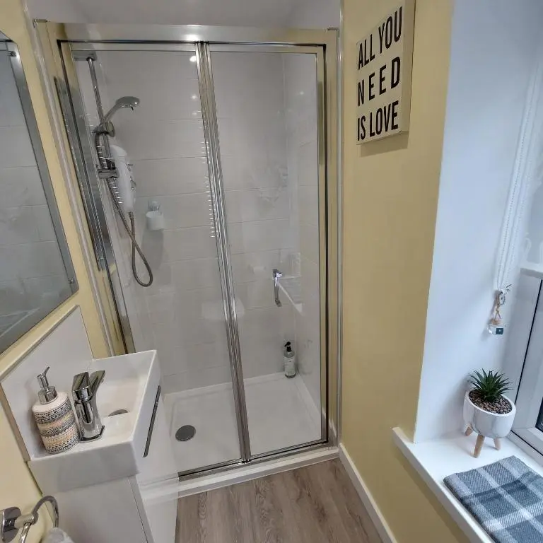 a bathroom with a shower and a sink at The Snug - Cosy Retreat for Two in Inverness