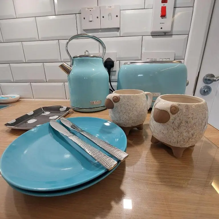 a table with two blue plates and a tea kettle at The Snug - Cosy Retreat for Two in Inverness