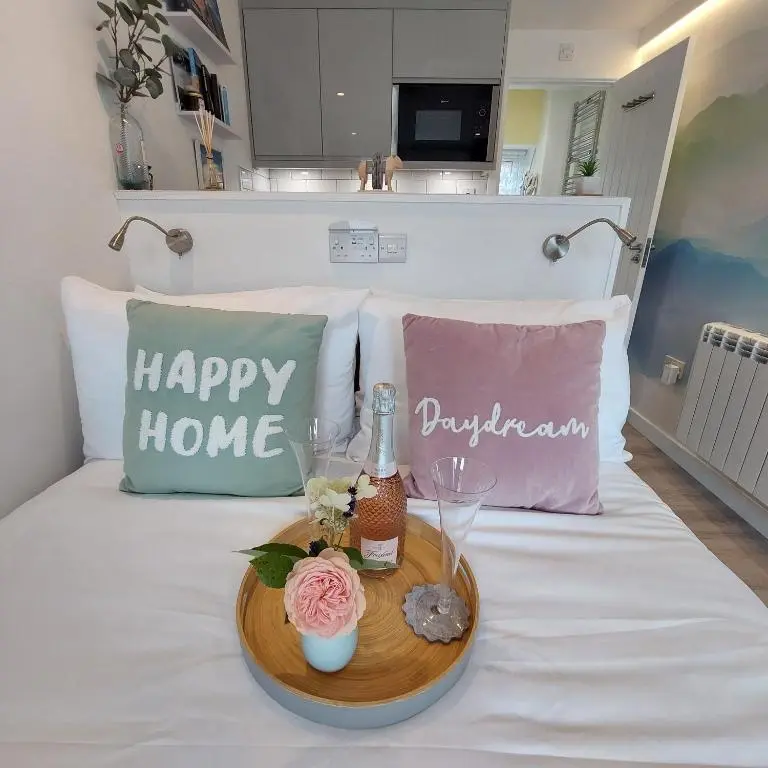 a tray with a bottle of champagne and glasses on a bed at The Snug - Cosy Retreat for Two in Inverness