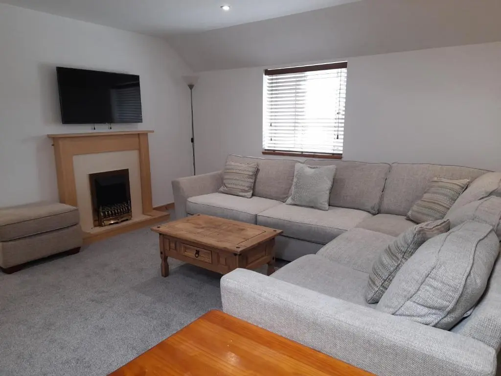 a living room with a couch and a fireplace at Culbokie Inn on the NC500 in Culbokie