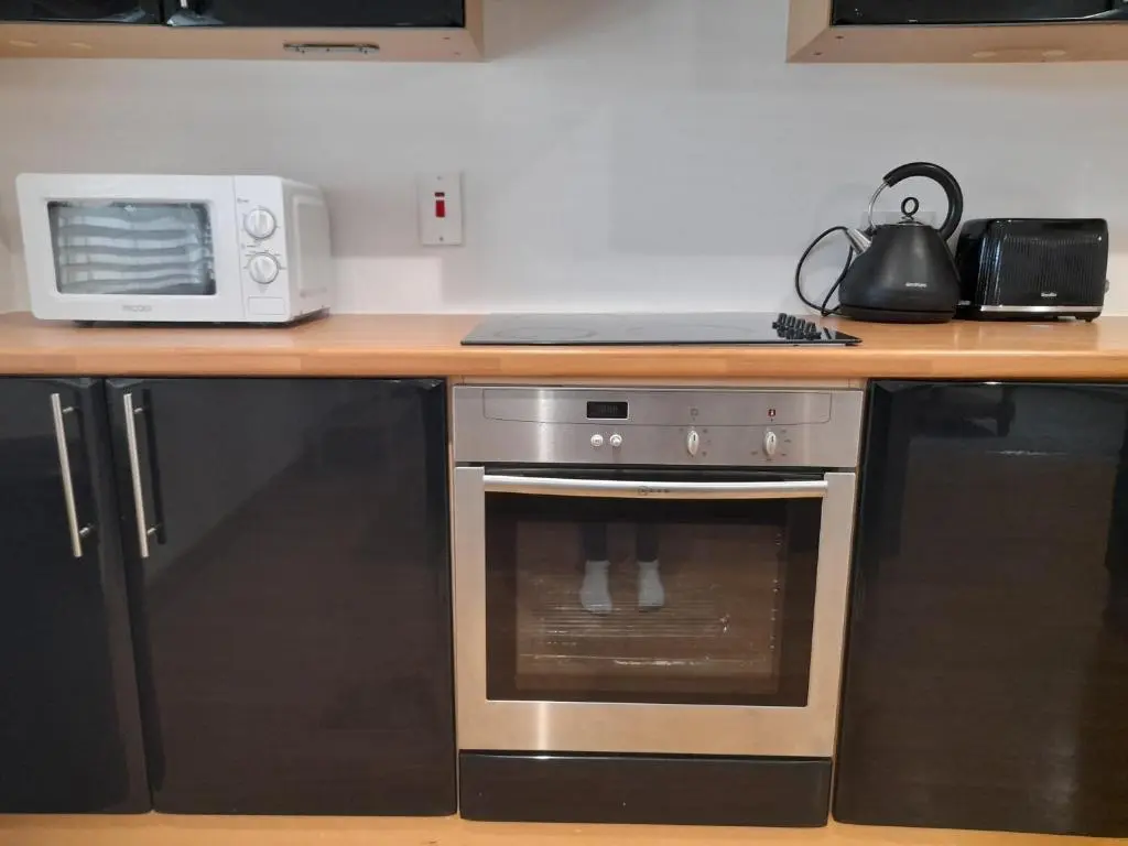 a kitchen with a microwave and a stove at Culbokie Inn on the NC500 in Culbokie