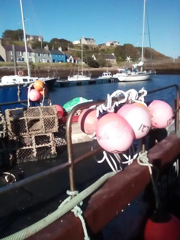 a boat with a bunch of equipment on the deck at Selkie House Sea Song in Helmsdale