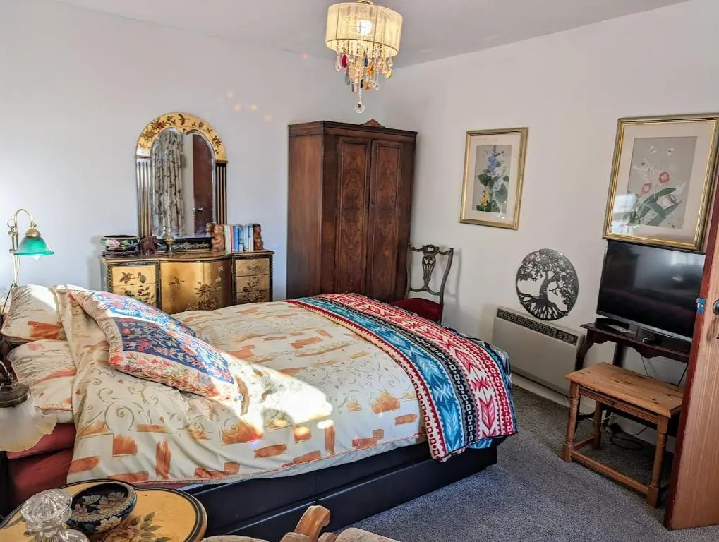 a bedroom with a bed and a tv and a table at Selkie House Sea Song in Helmsdale