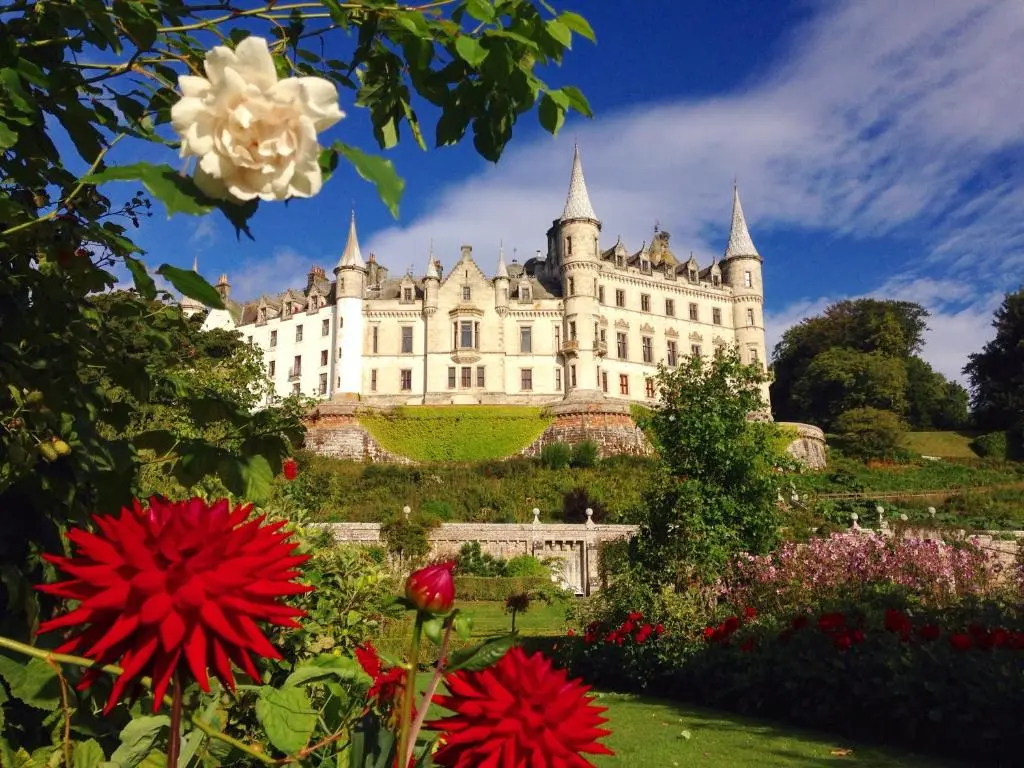 a large castle with flowers in front of it at Selkie House Sea Song in Helmsdale