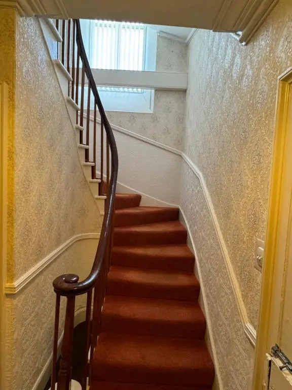 a staircase in a house with brown carpet at Spacious Harbour House in Wick