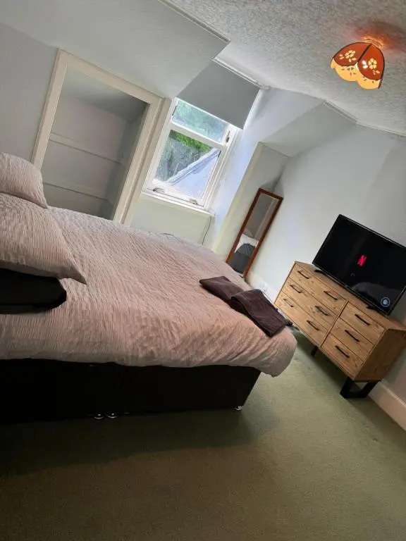 a bedroom with a bed and a flat screen tv at Spacious Harbour House in Wick