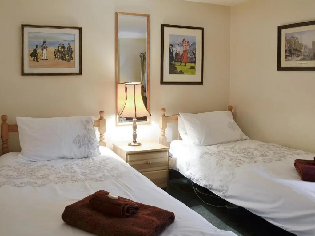 a bedroom with two beds with a towel on them at Rowan Tree Cottage - S4216 in Tulchan