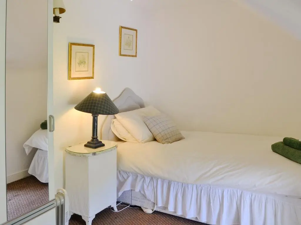 a bedroom with a bed with a lamp on a night stand at Dalvanie Mill - S4241 in Tulchan