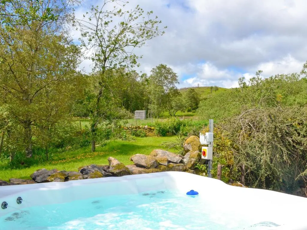 a hot tub in a yard with a garden at Dalvanie Mill - S4241 in Tulchan