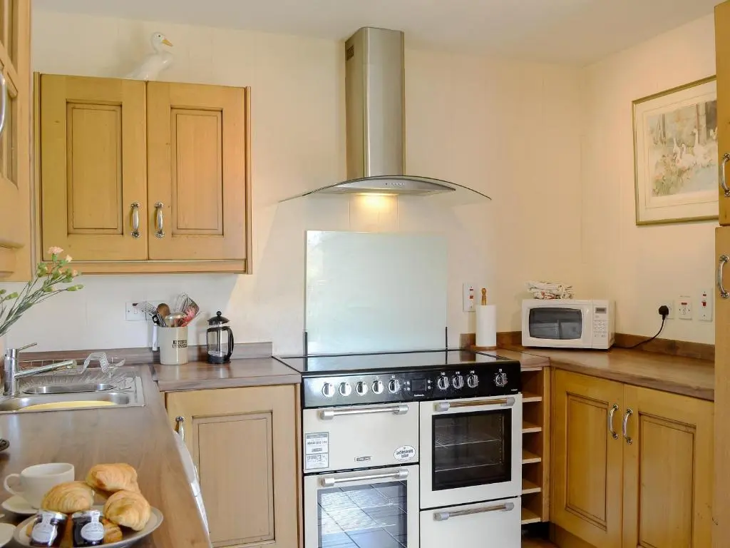 a kitchen with a stove and a microwave at Dalvanie Mill - S4241 in Tulchan