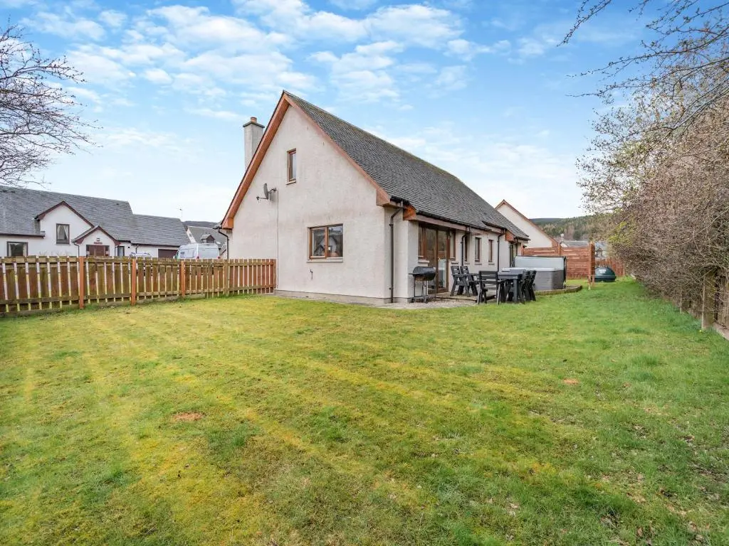 a white house with a fence and a yard at Cairn View - S4402 in Inverdruie