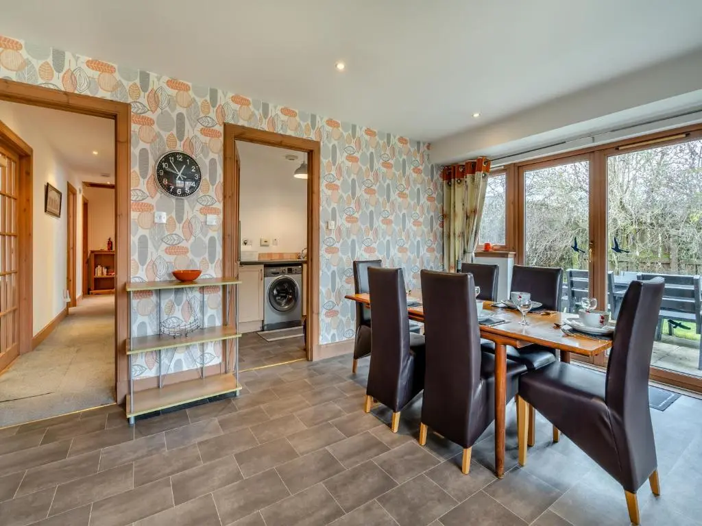 a dining room with a wooden table and black chairs at Cairn View - S4402 in Inverdruie