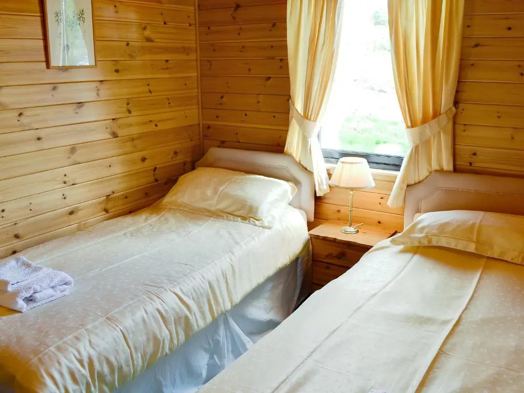 a small bedroom with a bed and a window at Larch Cottage - S4428 in Kirkton of Glenisla