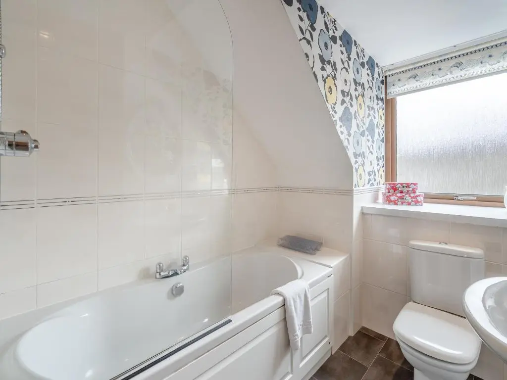a bathroom with a tub and a toilet and a sink at Coire Cas - S4538 in Inverdruie