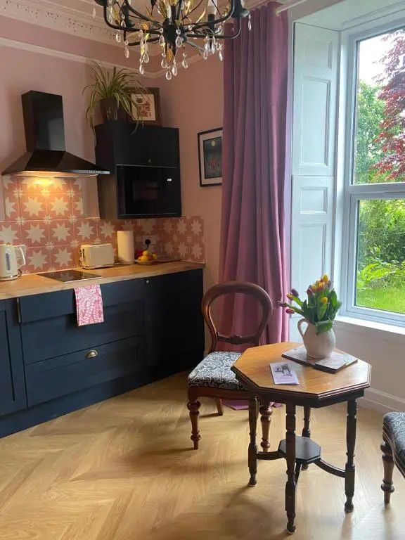 a kitchen with a table and a chair and a table at The Nest at Corbies Rest in Inverness