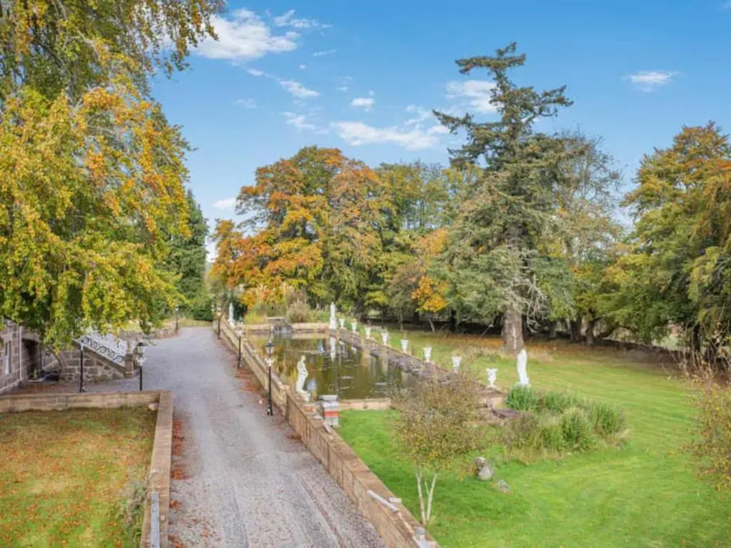 a path through a park with trees and water at The Doune, Luxury Traditional Country House with hot tub in Inverness