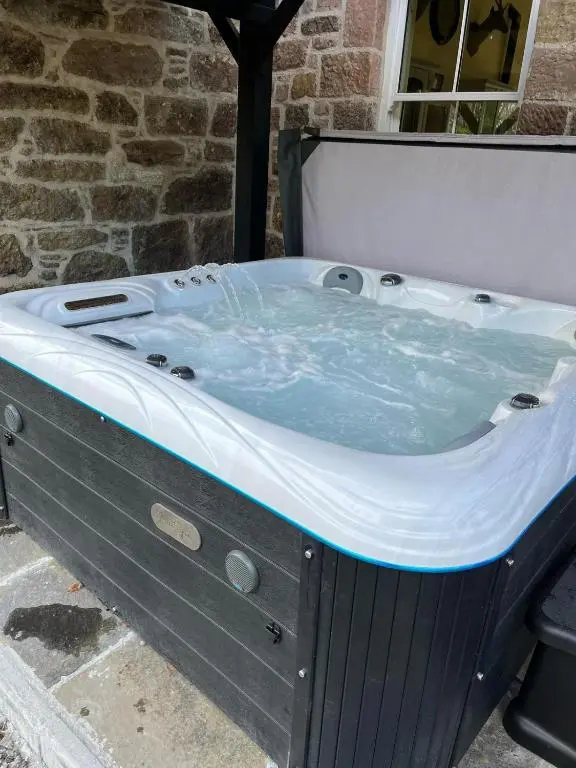 a jacuzzi tub sitting in front of a building at The Doune, Luxury Traditional Country House with hot tub in Inverness