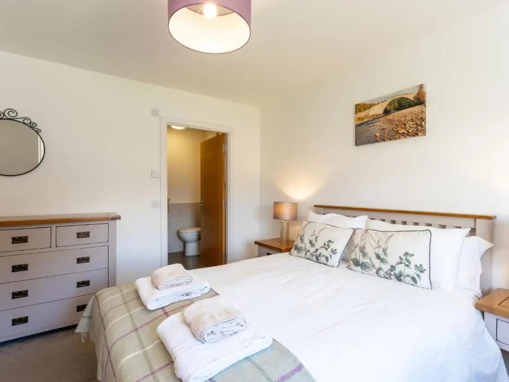 a bedroom with a bed with towels on it at Apartment The Muir by Interhome in Aviemore