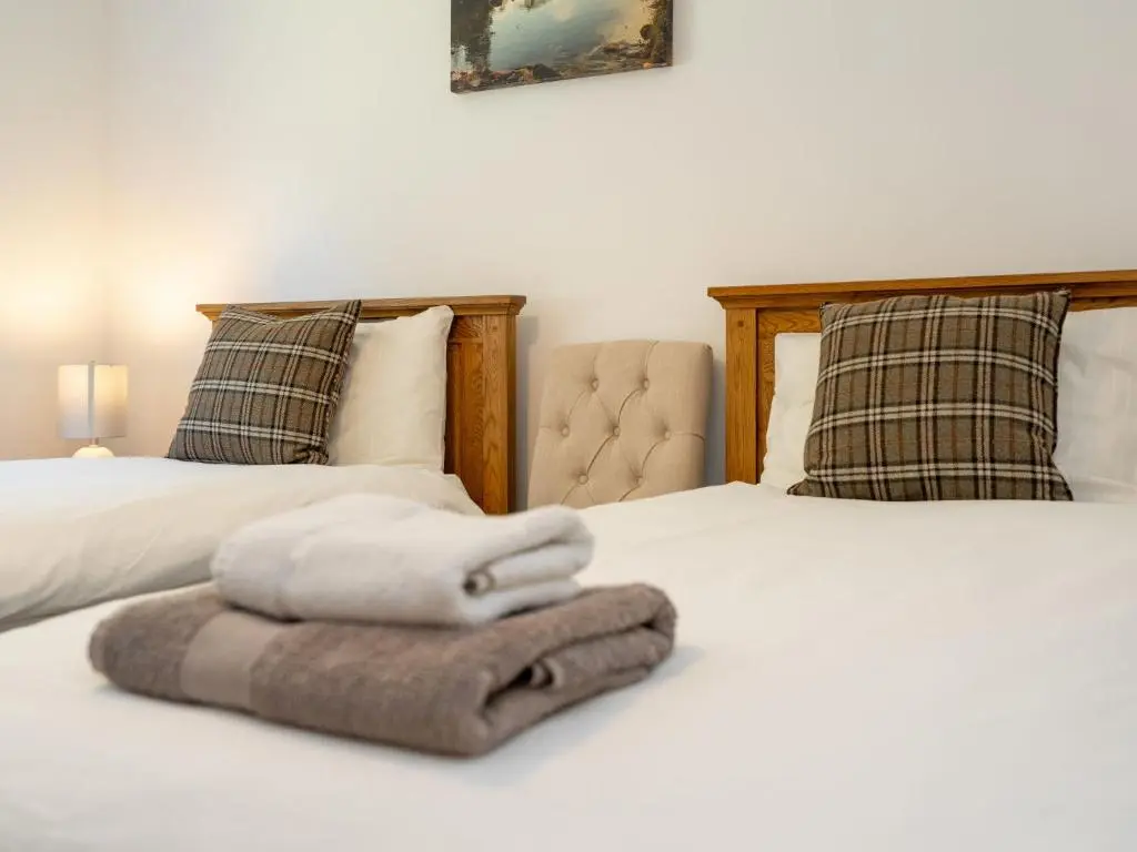 two beds with towels sitting on top of them at Apartment The Muir by Interhome in Aviemore