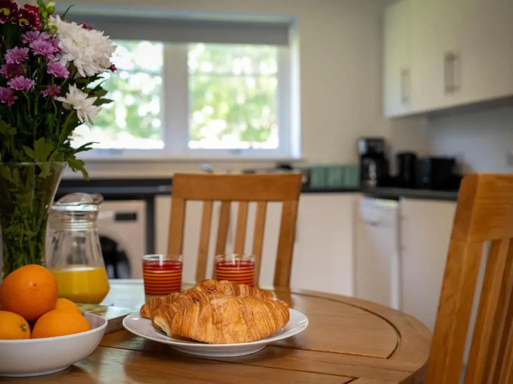 a table with a plate of bread and oranges on it at Apartment The Muir by Interhome in Aviemore