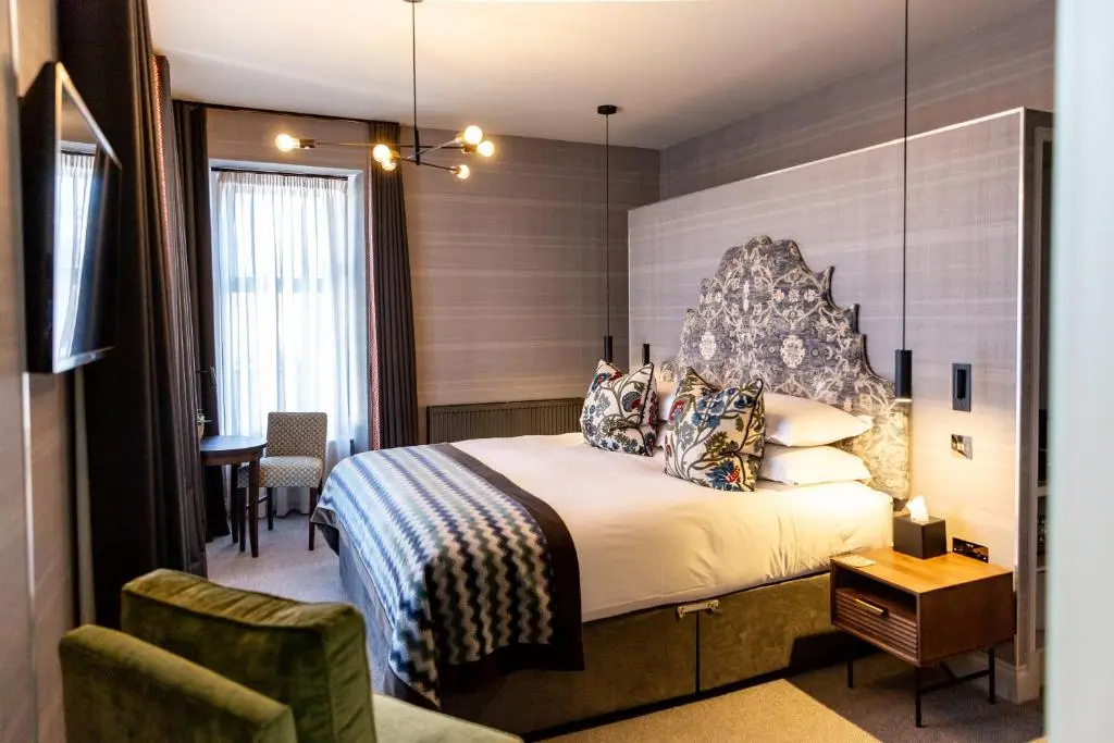 a hotel room with a bed and a chair at Hotel 1881 of Speyside in Archiestown