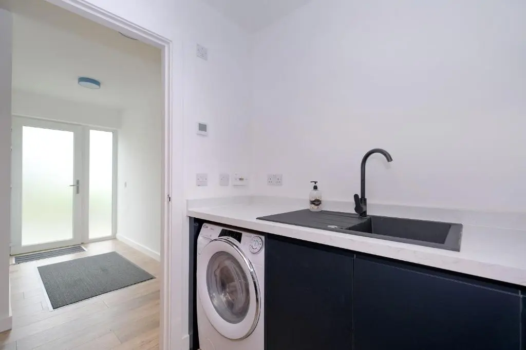 a kitchen with a sink and a washing machine at Contemporary Luxury Lodge, Aberdeen West in Blackburn