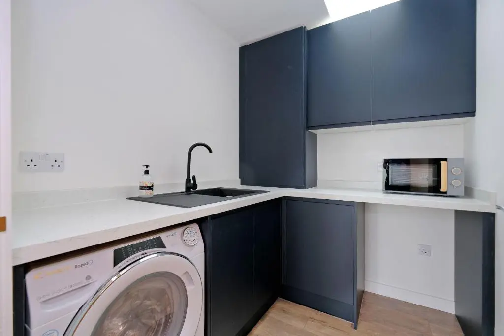 a kitchen with a washing machine and a sink at Contemporary Luxury Lodge, Aberdeen West in Blackburn