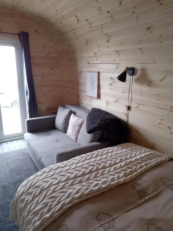 a bedroom with a bed and a couch in a room at Turadh 'a break in the clouds' in Dunbeath