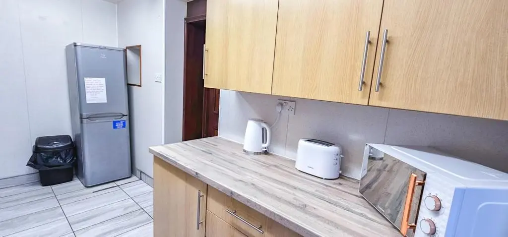a kitchen with a counter top and a refrigerator at Melrose Villa 11 Bedroom House in Inverness