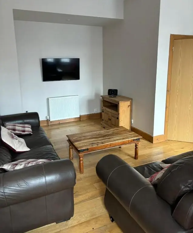 a living room with two couches and a coffee table at MacIver City Apartment Academy Street in Inverness