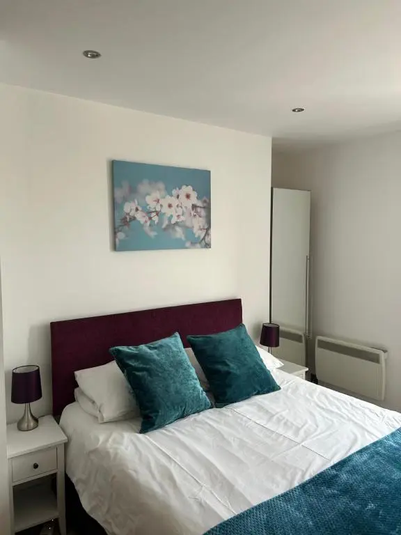 a bedroom with a large bed with blue pillows at 1 Bedroom Castleview Apartment 404-Free Parking in Inverness