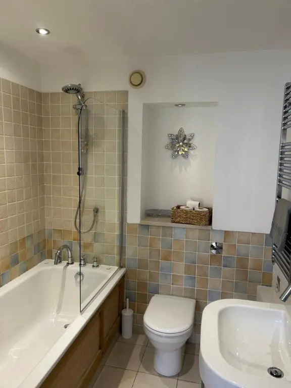 a bathroom with a tub and a toilet and a sink at 1 Bedroom Castleview Apartment 404-Free Parking in Inverness
