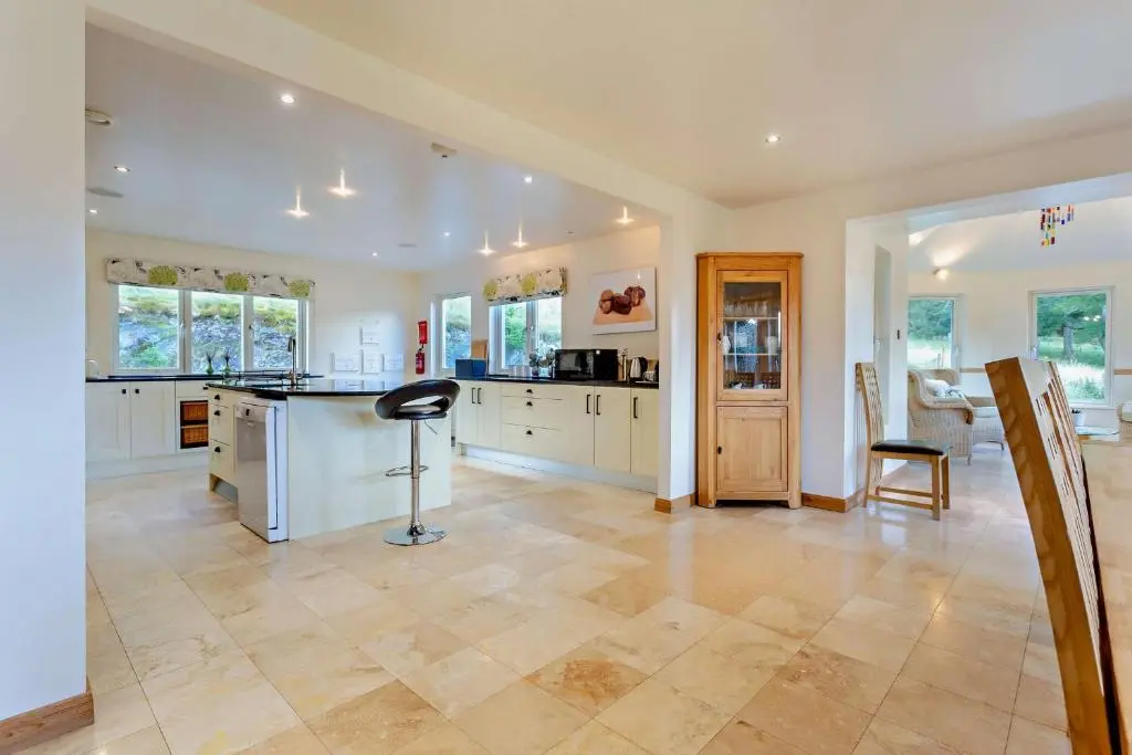 a large kitchen with white cabinets and a counter top at Sealladh an Loch in Foyers
