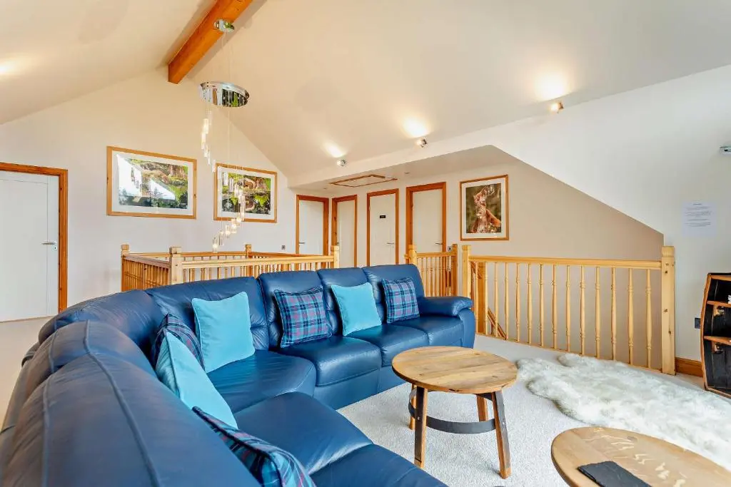 a living room with a blue couch and a table at Sealladh an Loch in Foyers