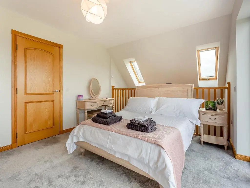 a bedroom with a large bed with towels on it at The Larches - Uk46804 in Culbokie