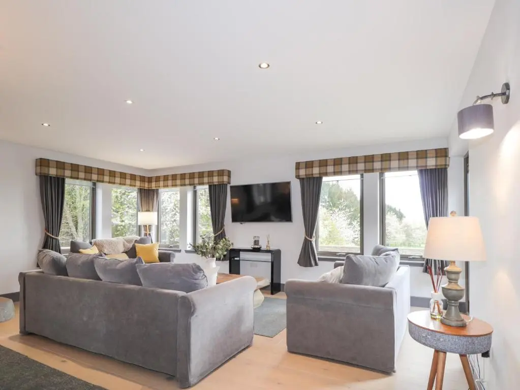 a living room with two couches and a tv at Ben Luna Lodge in Inverness