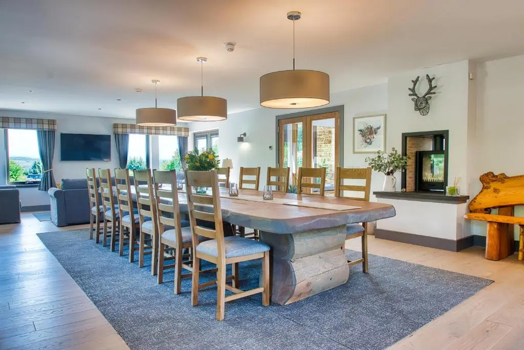a dining room with a large wooden table and chairs at Ben Luna Lodge in Inverness