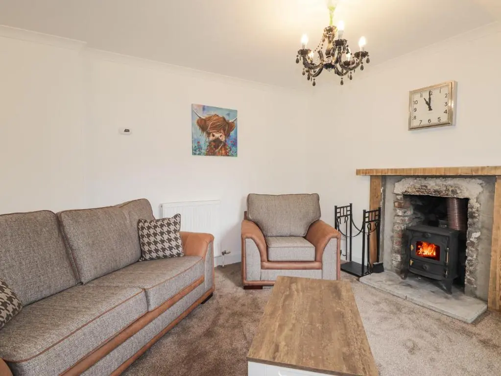 a living room with a couch and a fireplace at Apartment in Foyers in Inverness