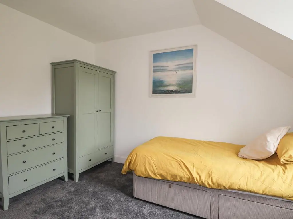 a bedroom with a bed and a dresser at Apartment in Foyers in Inverness