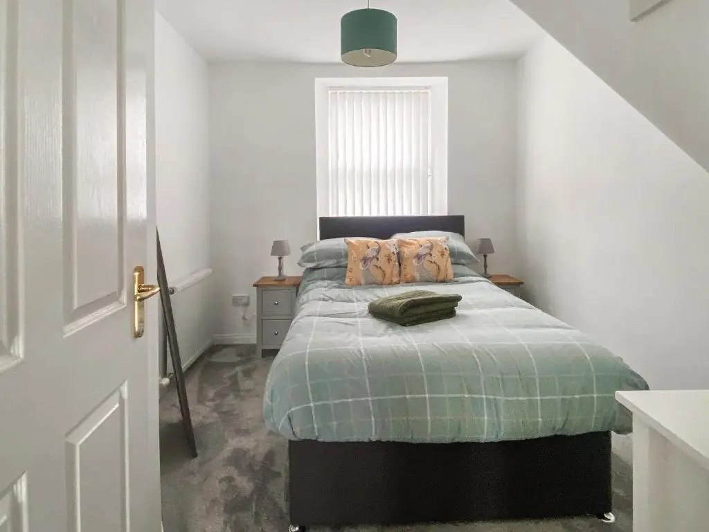 a bedroom with a bed with a green blanket at Guise Cottage Uk46303 in Tough