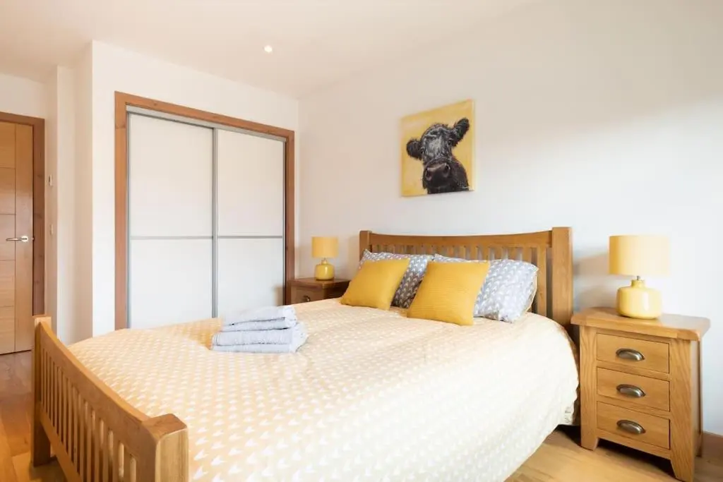 a bedroom with a bed with yellow and blue pillows at The Steadings in Aviemore