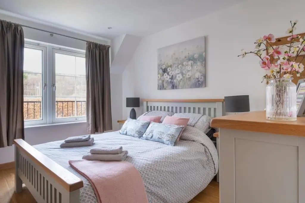 a bedroom with a bed with pillows on it at The Steadings in Aviemore