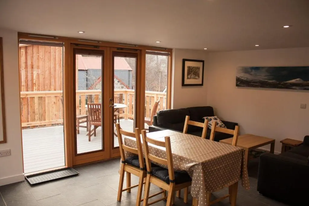 a living room with a table and a dining room at Carn Na Drochaide in Braemar