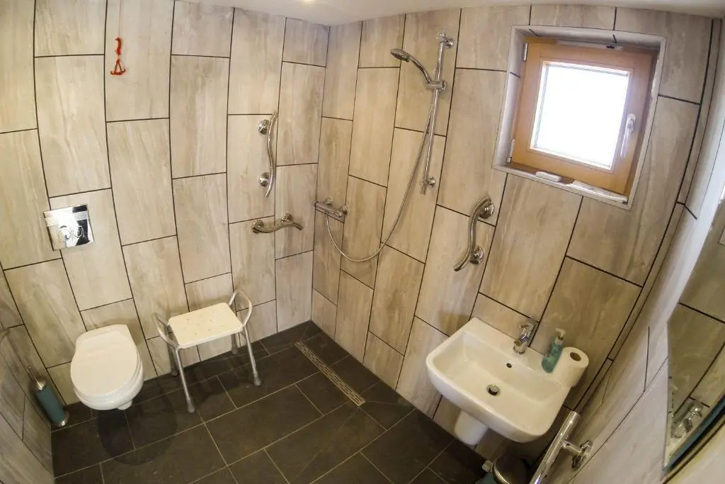 a bathroom with a shower and a toilet and a sink at Carn Na Drochaide in Braemar