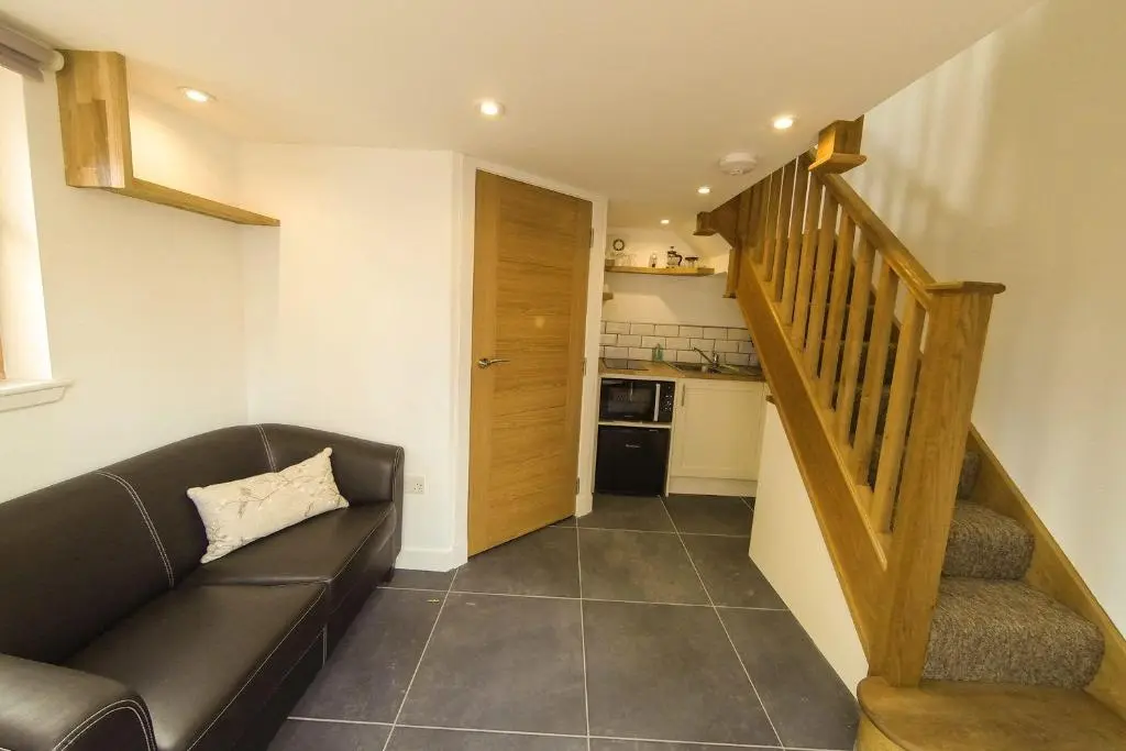 a living room with a couch and a stair case at Clunie in Braemar