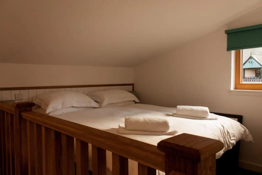 a bedroom with a bed with two pillows on it at Clunie in Braemar