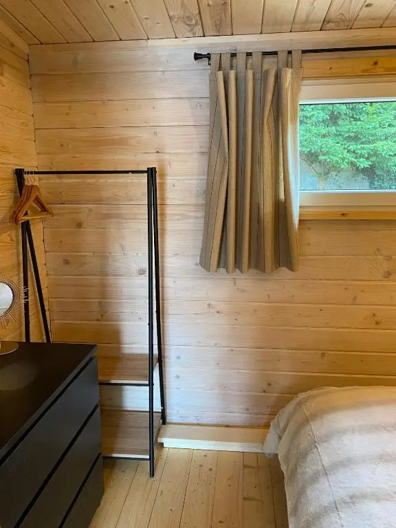 a bedroom in a log cabin with a bed and a window at Langdale Lodge in Inverness