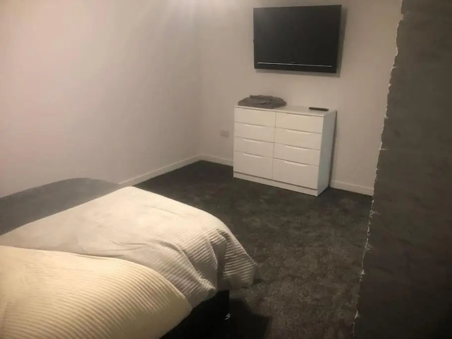 a bedroom with a bed and a tv on the wall at Lisbon 67 in Wick